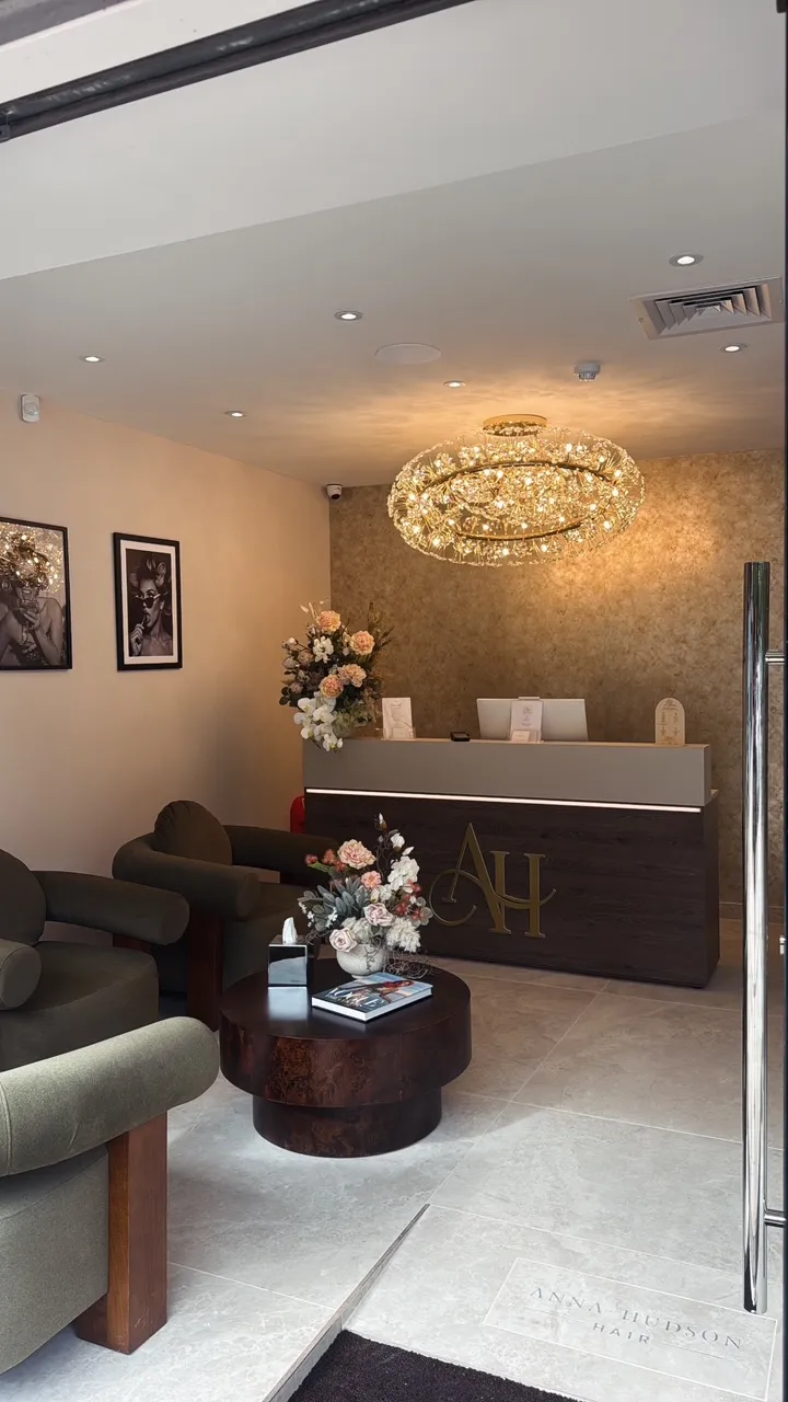 Lobby of in London, with a sofa set, side table, flower vase, books, and other objects on the table